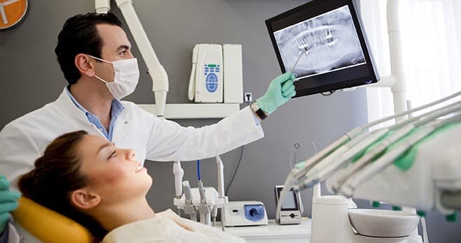 Dentist lookt at xrays with a patient